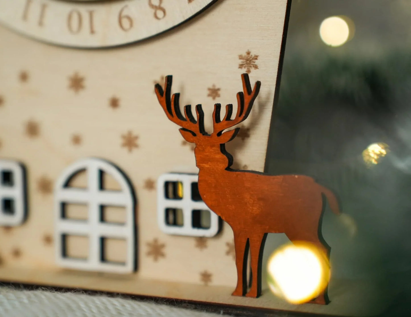 Kézzel készült fa rénszarvas dekoráció ablakos ház mellett, Zsempiri lakásdekor